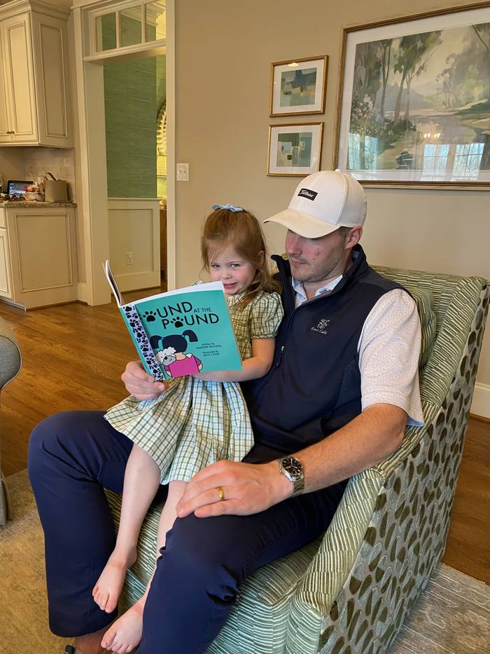 A father reading Found at the Pound with his young daughter on his lap