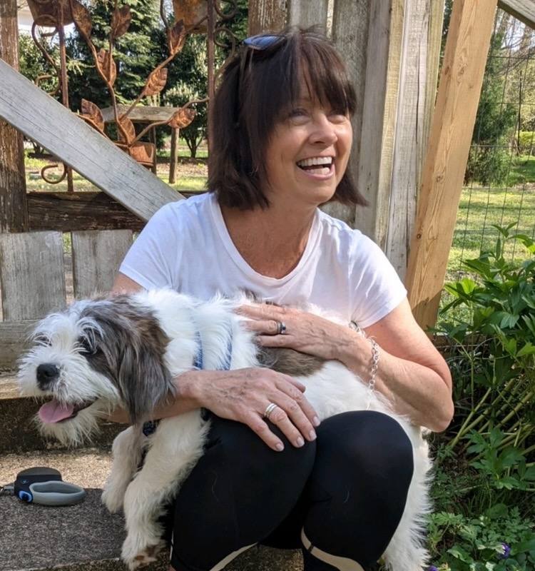 Maggie Mullikin laughing with her rescue dog